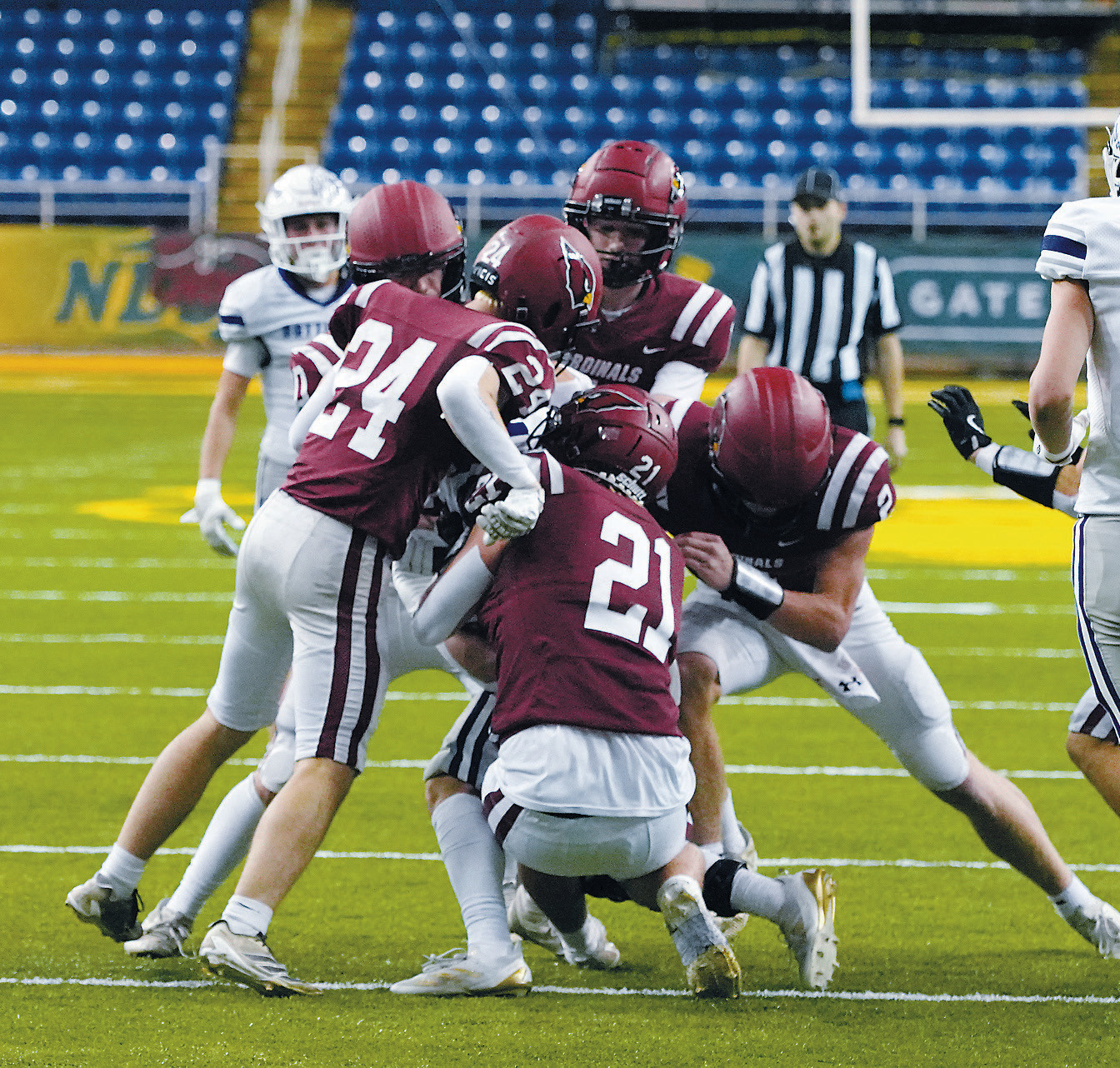 A flock of Cardinals swarm a Bottineau ball carrier to stop a first down at the Dakota Bowl. Photo by Larry Stokke.