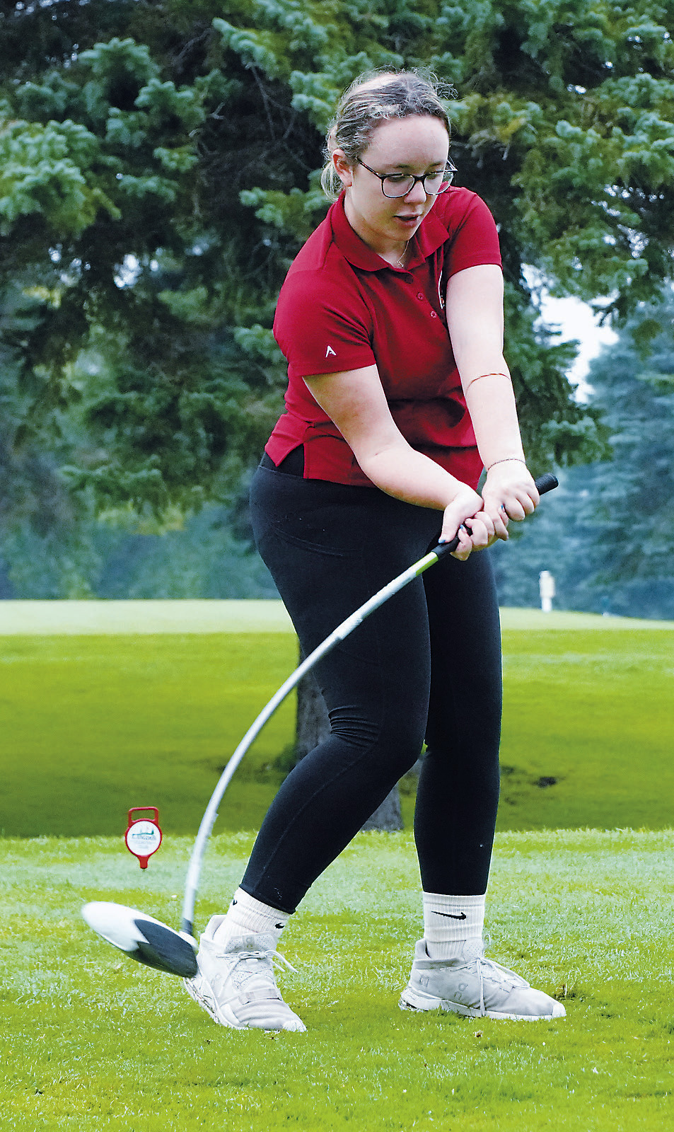 Kynlee Pengilly puts a bend in her club as she tees off in Langdon at the first meet of the school year. Photo by Larry Stokke.
