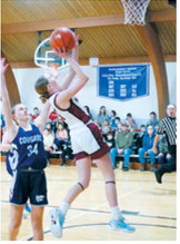 Ary Schaefer drives past a Cougar player and rolls in a basket. Photo by Larry Stokke