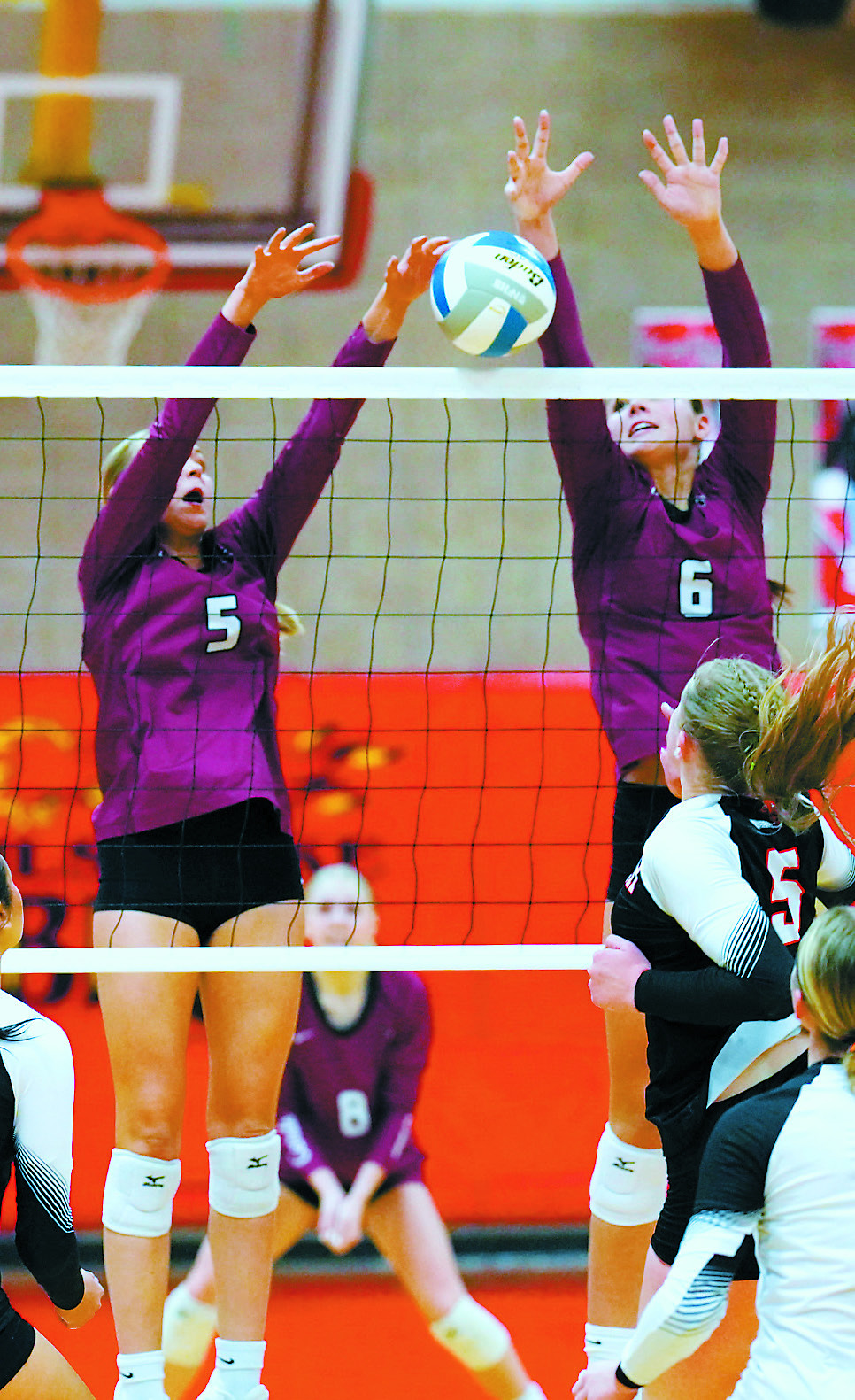 Hallie Overby and Taya Feist team up for a stuff block at the net in the three-set win over the Cavalier Tornadoes. Photo by Larry Stokke.