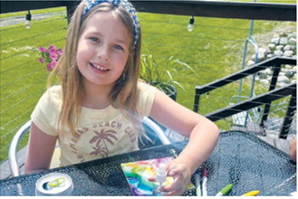 A young artist works on a colorful painting outdoors during the Encore Arts Camp at Frost Fire Park. Campers spent the week exploring their creativity while enjoying the park's scenic setting. Submitted photo