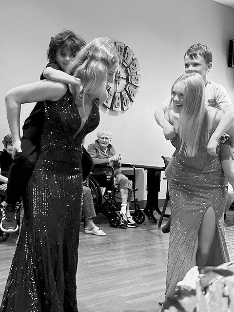 Kate (left) and Jacy (right) play with younger students during prom 2025.