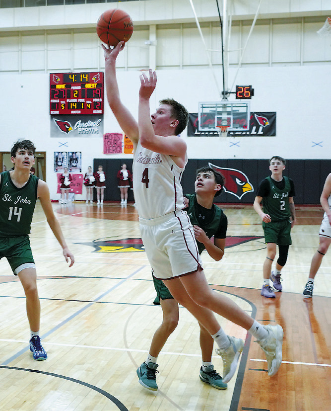 Levi Swanson eyes the basket and lays in a bucket. Photo by Larry Stokke.