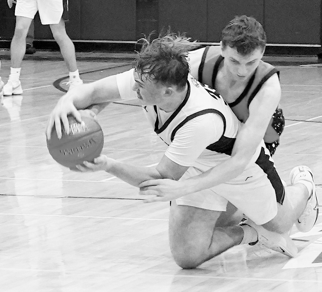 Kade Schafer dives after a loose ball and fights for possession. Photo by Larry Stokke.