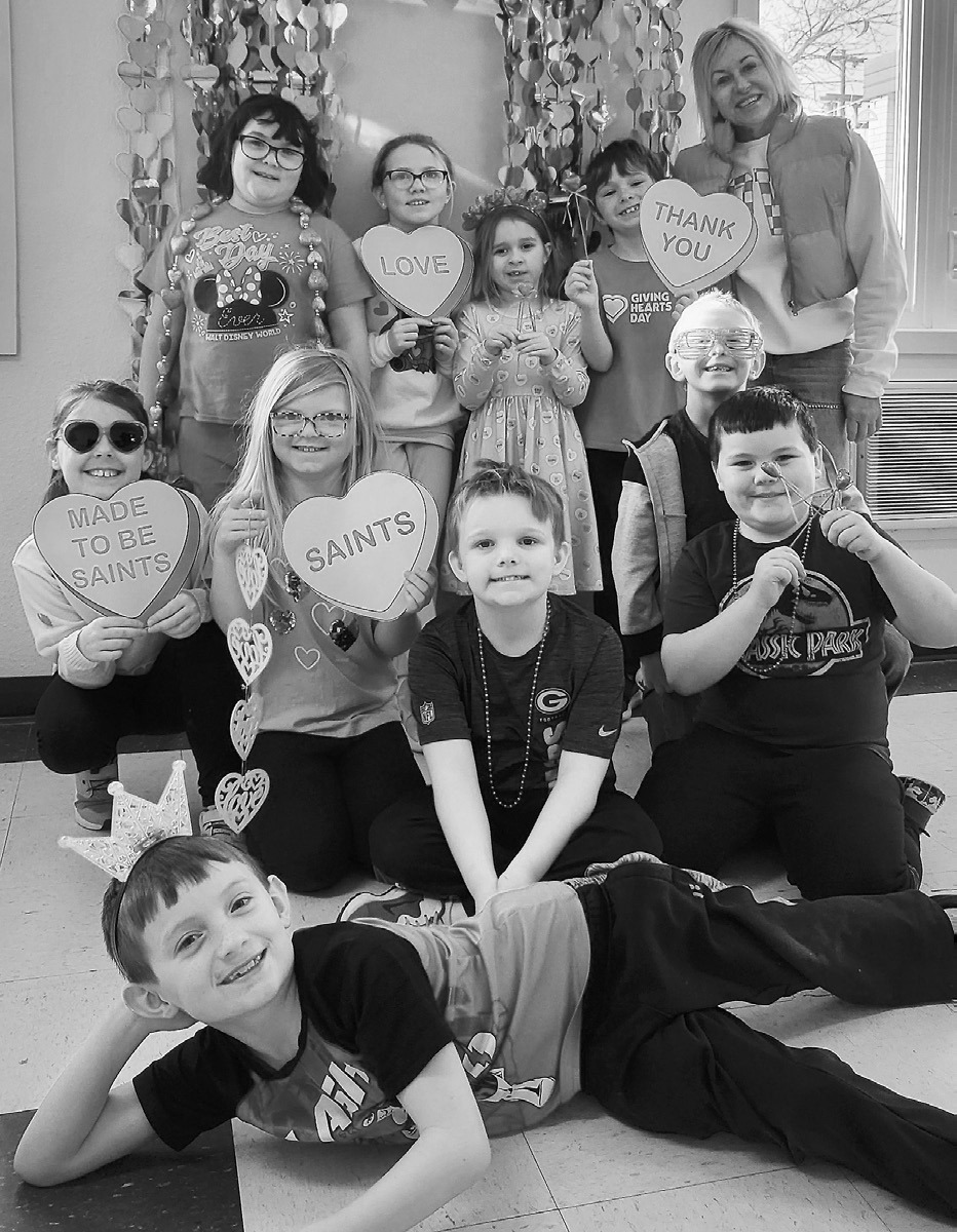 Our second grade class poses in front of our Giving Hearts Day photobooth. St. Alphonsus School photo.