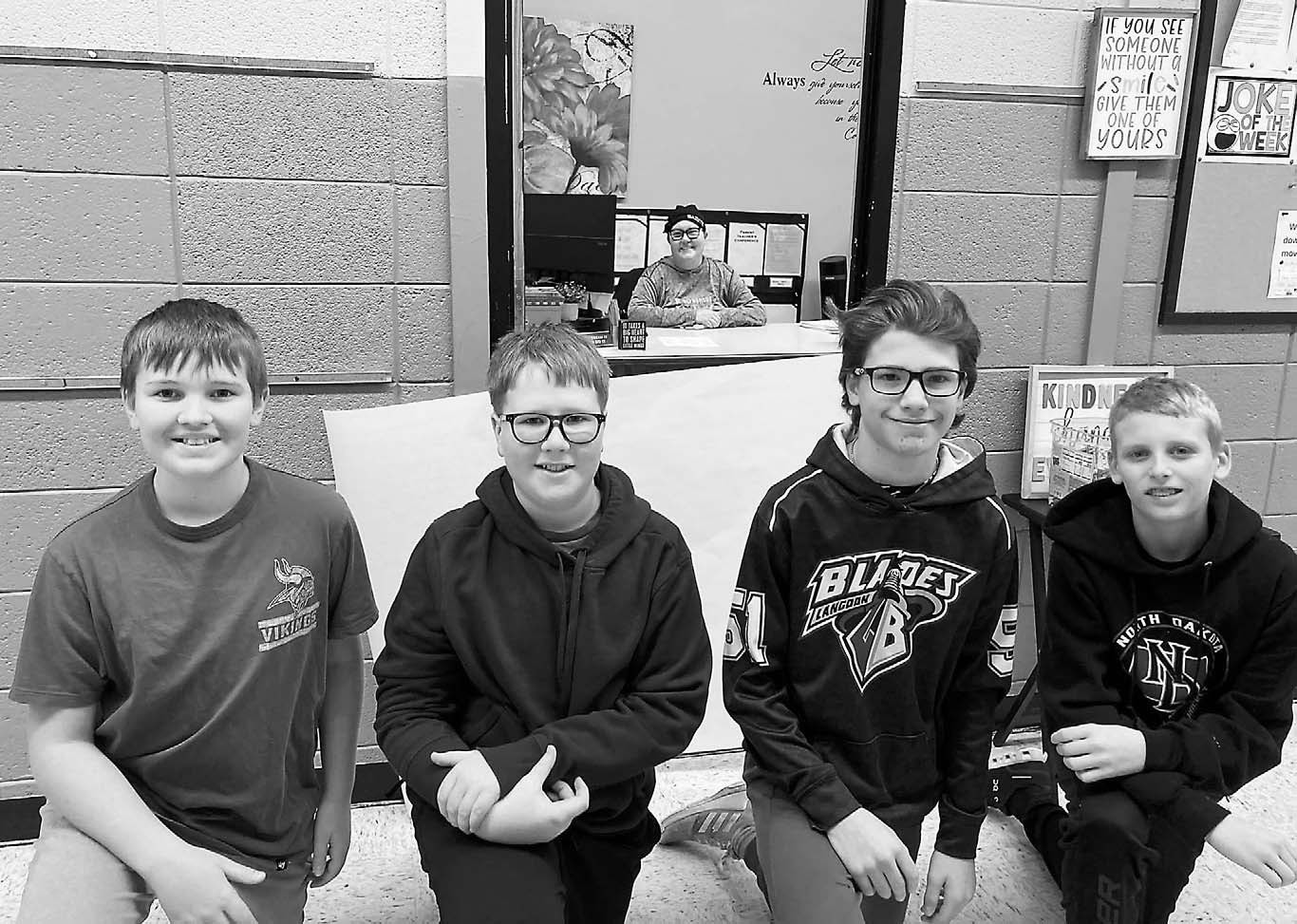 Students stand in front of Carrie's office door for a photo.
