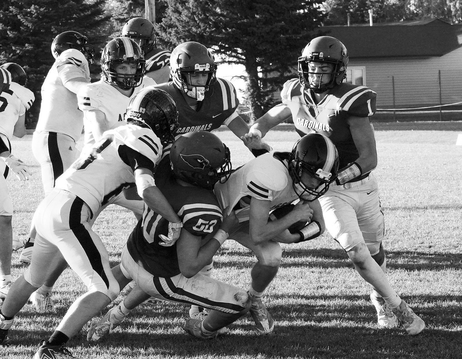Landon Schneider wraps up an Aggie ballcarrier. Photo by Larry Stokke.