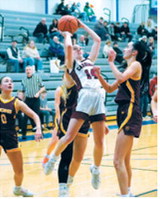 Hilary Haaven drives to the basket between four Linton HMB players and drops in a basket. Photo by Larry Stokke