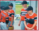 A young fan receives a hug from a Langdon player while visiting with the team outside the dugout before the game. The players shared smiles and conversation as they prepared to take the field. Submitted photo