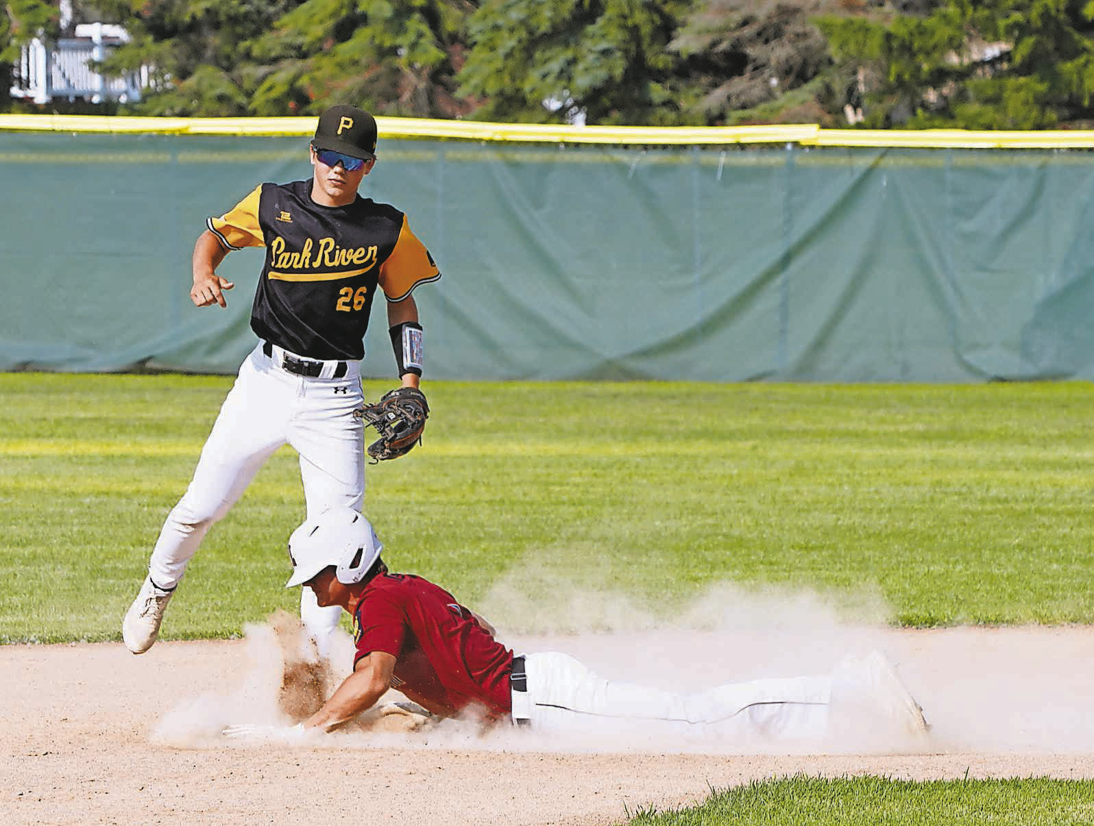 Nick Kingzett slides headfirst into base during the Red Sox win over Park River. Photo by Larry Stokke.