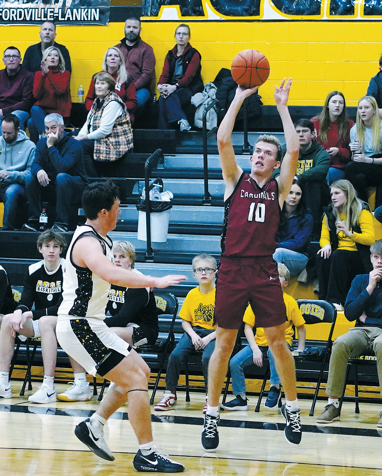 With his Grandmother and parents watching, Maddux Stremick nails one of his three-point baskets, finishing the game with 11 points in the win over the Aggies. Photo by Larry Stokke.