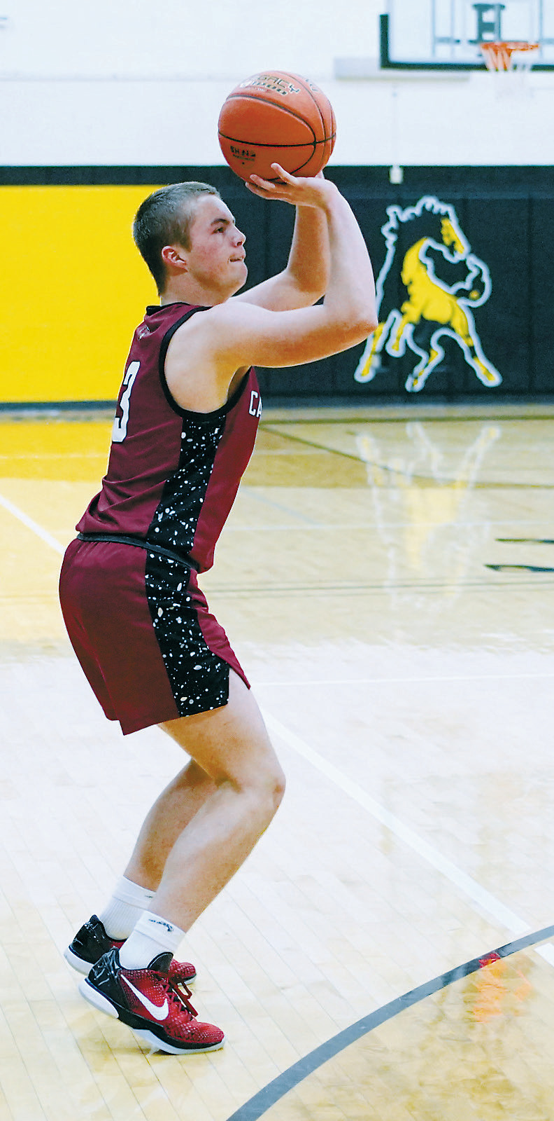 Dawsin Downs drains a three-point basket in the Cards' win in Park River over the Aggies. Photo by Larry Stokke.