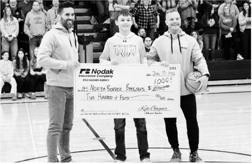 Kyle Gagner, Nodak Insurance of Cavalier and Ryan Beattie, Nodak Insurance of Langdon, are pictured with Asher Crosby and the donation that will be made to the North Border Boosters. Photo by Larry Stokke.