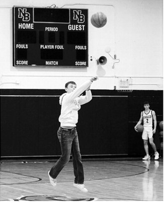 Asher Crosby launches a half-court shot during halftime. Photo by Larry Stokke.