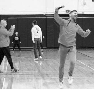 Pictured are Ryan Beattie, Asher Crosby, and Kyle Gagner all reacting to Crosby making the halfcourt shot. Photo by Larry Stokke.