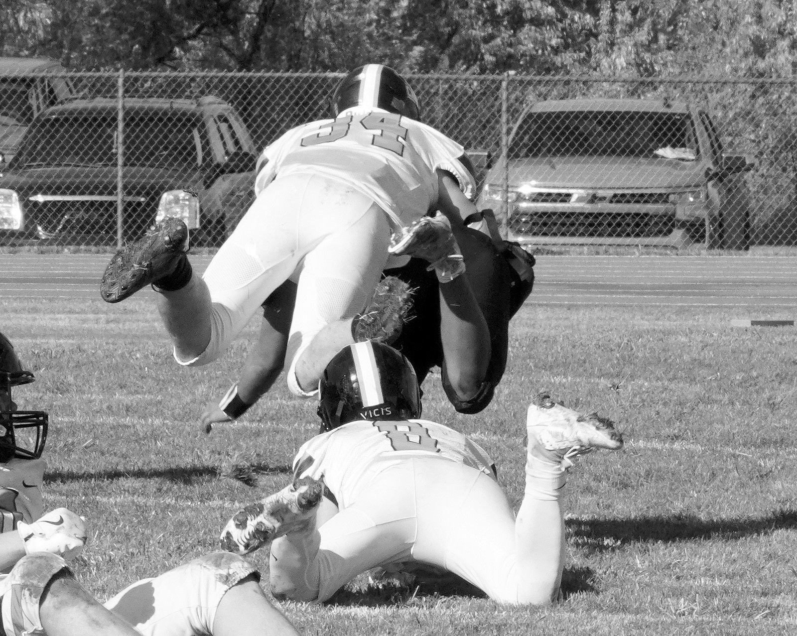 Jonas Kuhn leaps over Logan Werner and tackles a Four Winds player. Photo by Larry Stokke.