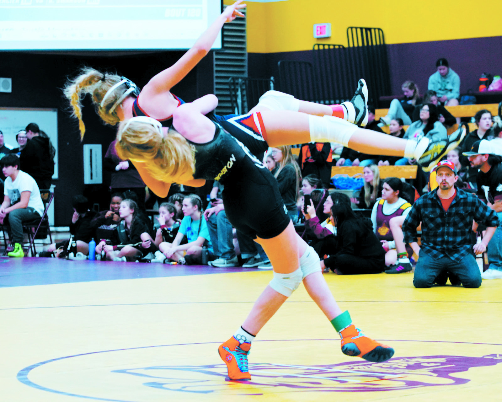 Charlotte Crowston with a strength move picks up her Mayport opponent and brings her to the mat to grab a win. Photo by Larry Stokke.