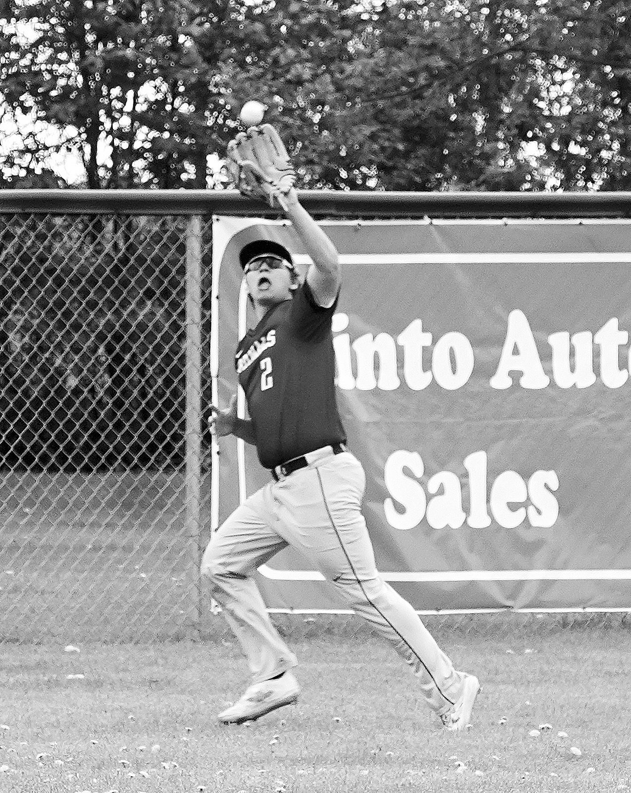 Cole Welsh makes a catch at the fence in center field for a 3rd out against Grafton on May 20 in Minto. Photo by Larry Stokke.
