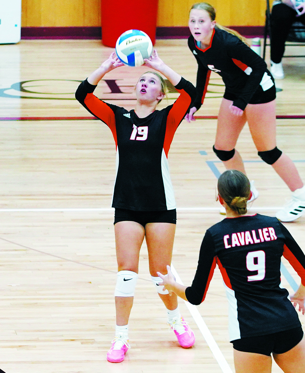Brynn Devine eyes the ball and sets to a teammate against the Cards. Photo by Larry Stokke.