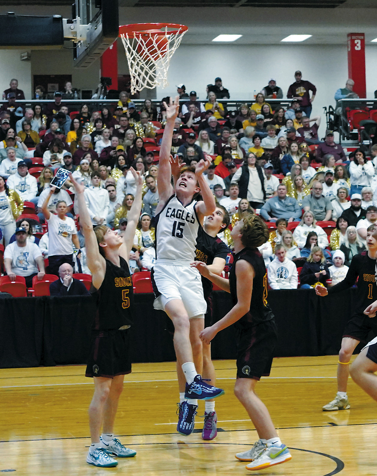 Player of the Game against Westhope/Newburg, Garret Willits, goes to the basket between three defenders and adds 2 points to the Eagles' score. Photo by Larry Stokke.