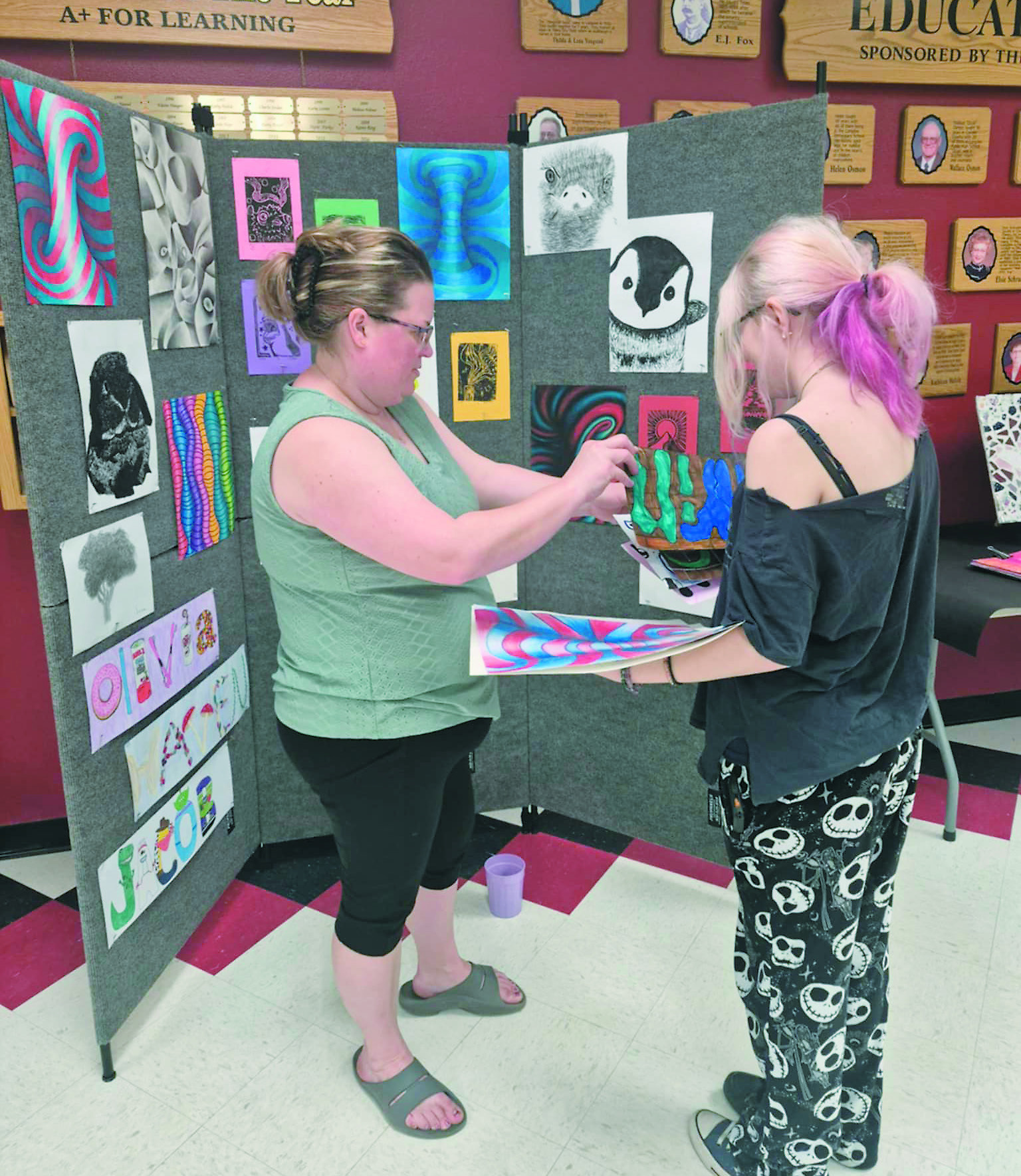 Mindi Lill and Charlie Zbasnik work together to set up the show in the Langdon High School Commons.