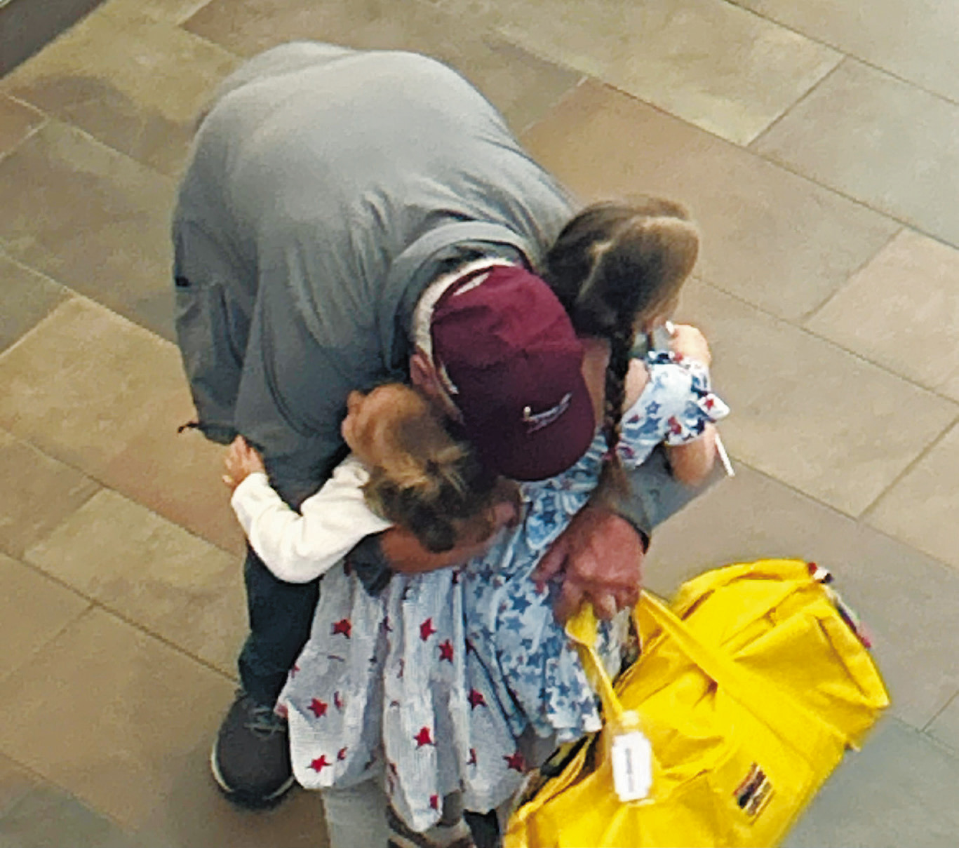 A veteran and grandfather greets his granddaughters after he arrived home from the Honor Flight. Photo by Rebecca Davis.
