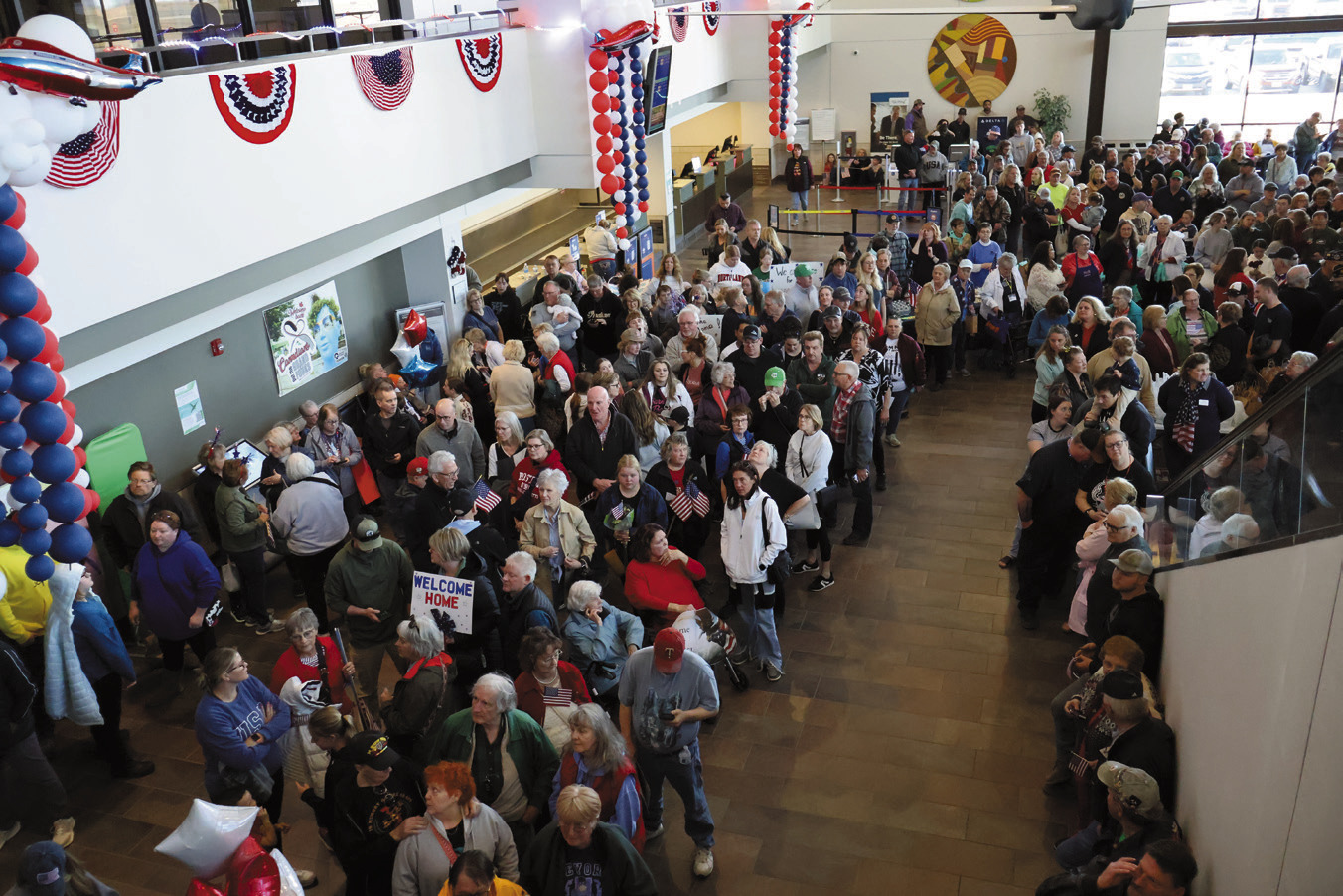 A crowd filled the airport to greet the veterans and welcome them home after their Honor Flight. Photo by Rebecca Davis.