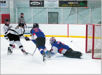 Colby Forest sends the puck past the Richland goalie and finished the game with 3 goals for a Hat Trick. Photo by Larry Stokke.
