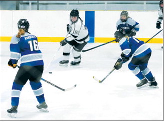 Kenadee Cluchie brings the puck up under pressure from 3 defenders. Photo by Larry Stokke.