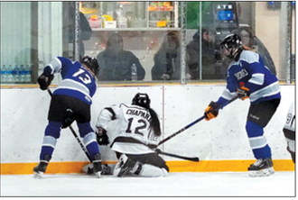 Aishwarya Chapara scraps with two Richland players for control of the puck. Photo by Larry Stokke.