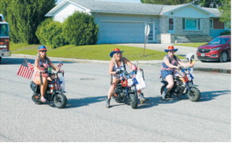 Patriotic riders cruise through the Pre-Blast Bash parade on decorated mini bikes, spreading red, white and blue spirit along the route. Photo by Larry Stokke