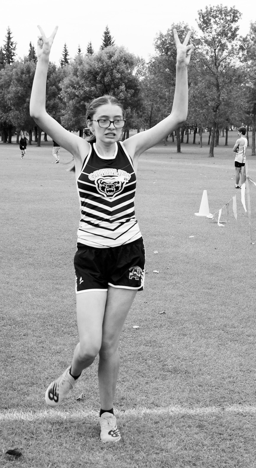 Maddy Robinson celebrates after crossing the finish line in 5th place. Photo by Larry Stokke.
