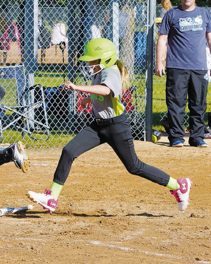 Kena Pritchard crosses home plate and scores a run for the Langdon Green Giants. Photo by Larry Stokke.