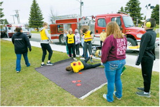 A hands-on safety demonstration teaches students how emergency personnel respond to accidents and other emergencies during Elementary School Safety Day on May 18. Photo by Larry Stokke