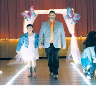 Nadiya and her father, Nyk Hope, are announced and walk down the runway during the Butterfly Ball held April 17 in Langdon. The event raised funds for the Cavalier County Cancer Crusaders. Photo by Katie Polansky Photography.