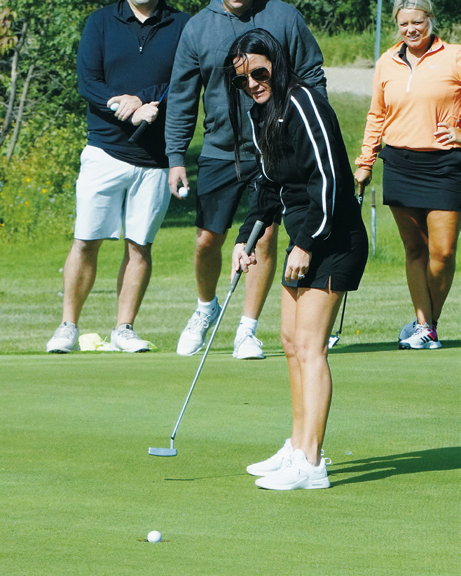 Christy Hanson drops the ball in the cup at the Frost Fire golf tourney on Aug. 16. Photo by Larry Stokke.
