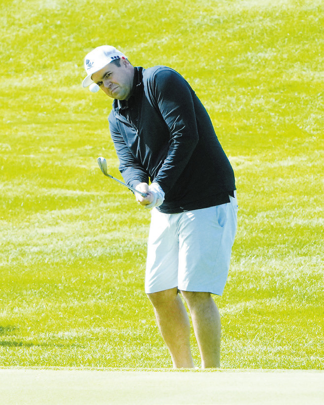 Joel Smith eyes the ball as he chips it up on the green at Frost Fire's golf tournament. Photo by Larry Stokke.