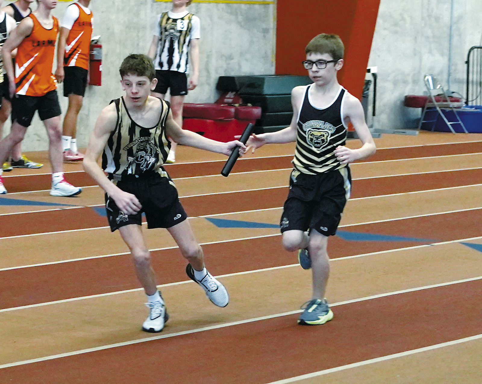 Collin Longtin takes the baton from Gavin Bjornstad who, along with teammates Logan Heuchert and Kylan Schafer, took 9th place in the 4X300 relay. Photo by Larry Stokke.