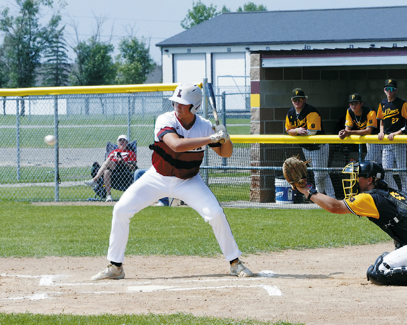 Landon Schneider eyes the ball before launching it into the outfield. Photo by Larry Stokke.