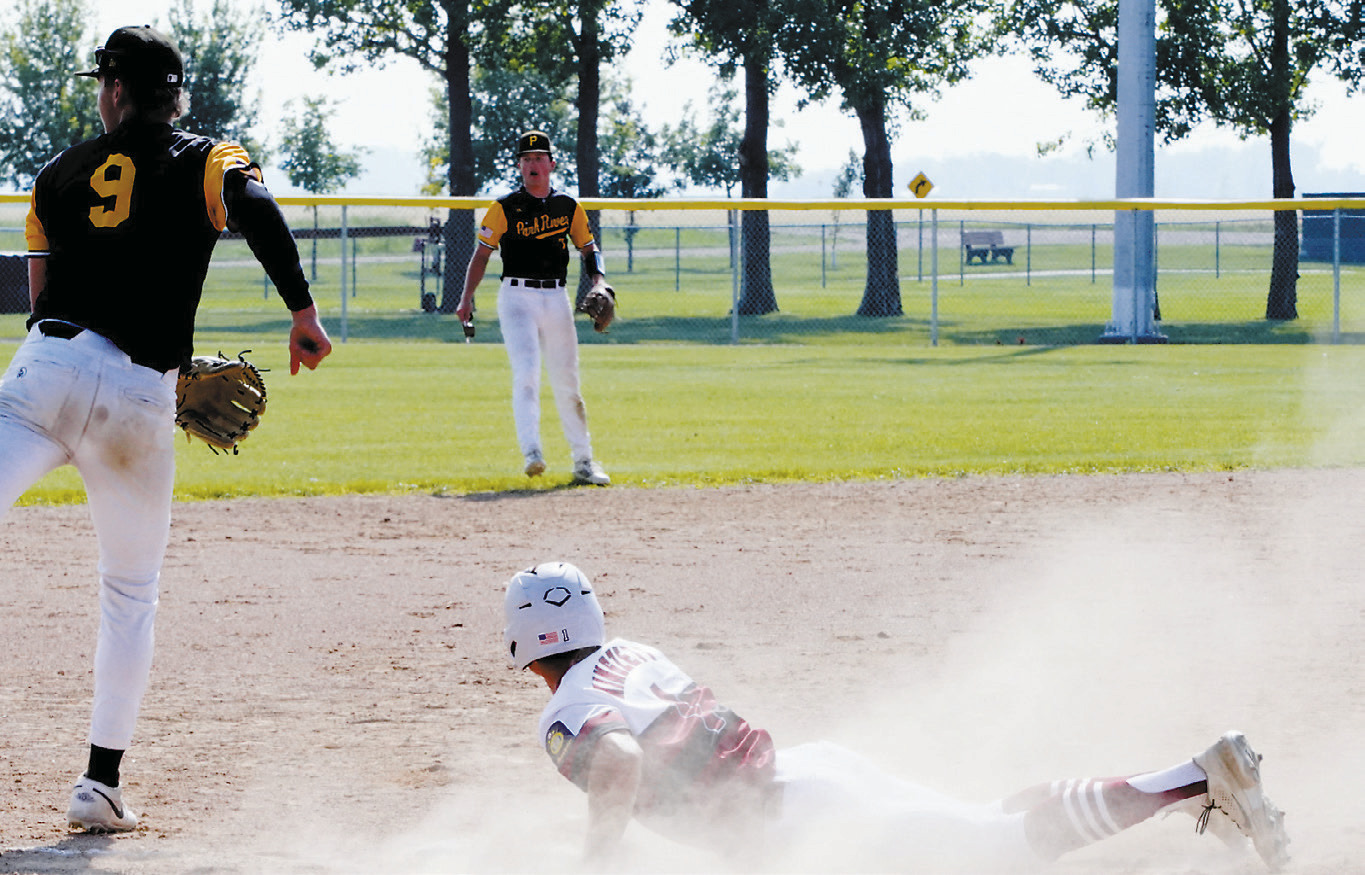 Nick Kingzett dives back to third base in the game against Park River. Photo by Larry Stokke.