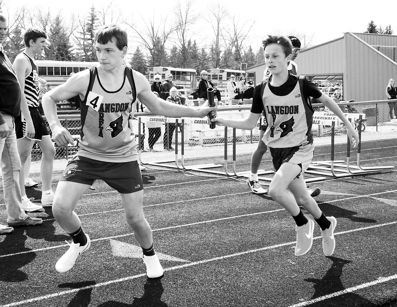 Competing in the 4X800 relay, Prestyn Bodnar hands off the baton to Tyler Borgan who, along with teammates Noah Foster and Kaleb Foster, placed 2nd in the Langdon Invitational Meet. Photo By Latty Stokke.