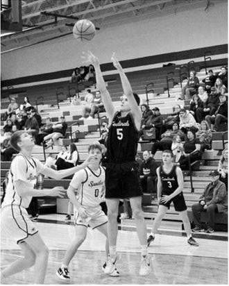 TJ Henderson nails a basket against the Spoilers. Photo by Larry Stokke