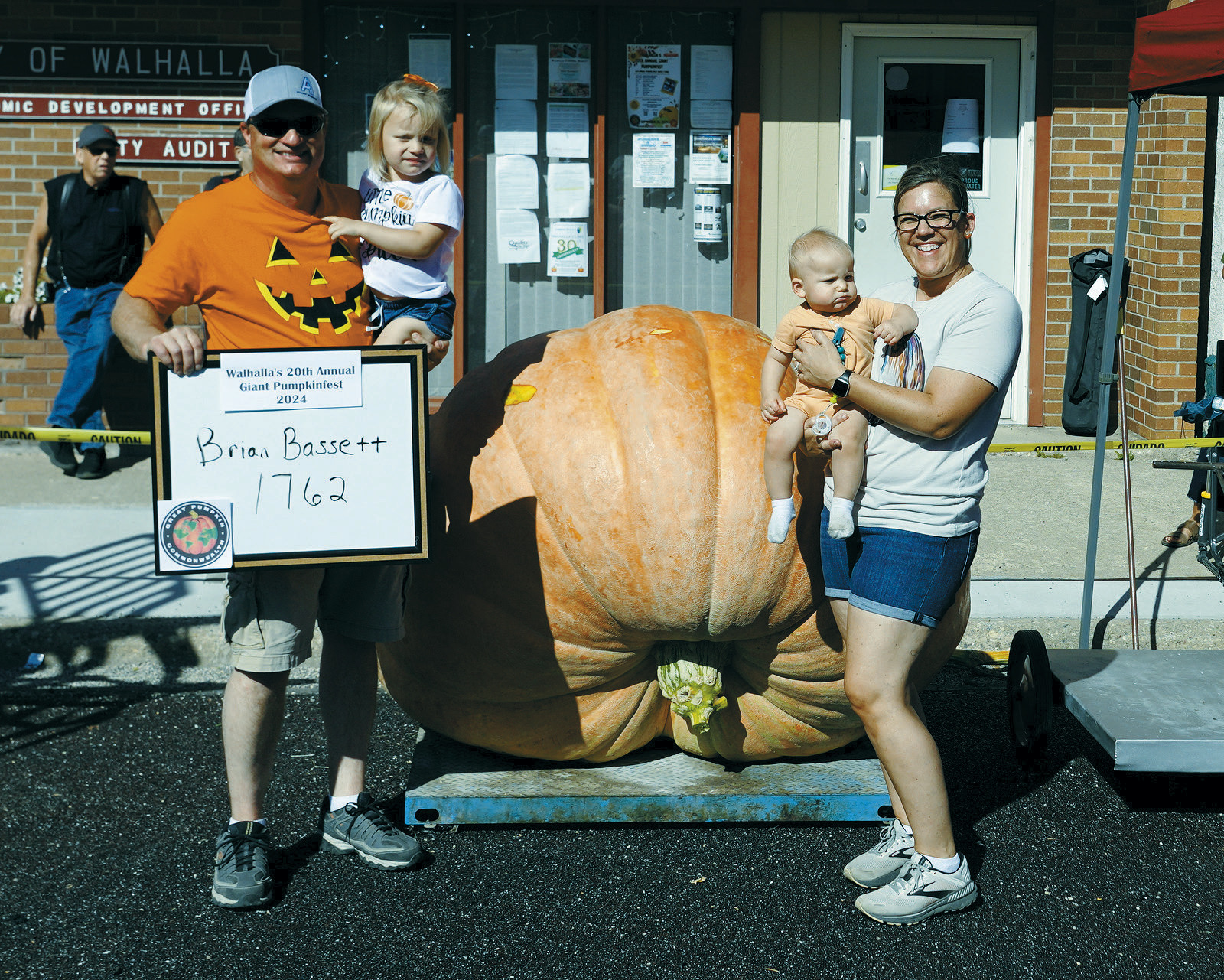 Brian Bassett with his family pose in front of his 1,762 pound pumpkin. Photo by Larry Stokke.