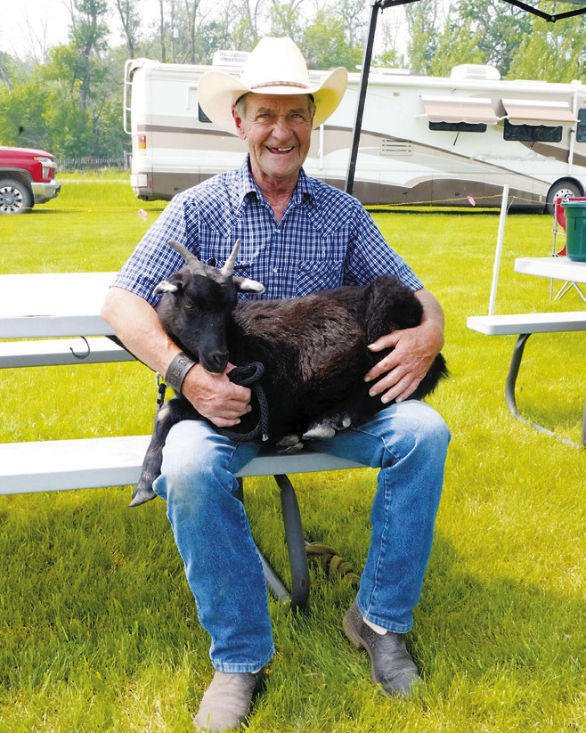 Ben Hannesson holding his goat, Kevin. Photo by Larry Stokke.