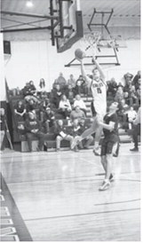 Garret Willits goes to the basket and lays in two points over a North Prairie defender. Photo by Ashley Schafer.