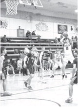 Colton Bailly tackles a jump shot while defenders look on. Photo by Ashley Schafer.