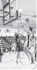 In traffic, Kaden Moore lays one in for two points. Photo by Ashley Schafer.