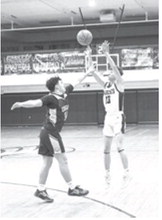 Rhyder Girodat shoots for three over the hands of the North Prairie defense. Photo by Ashley Schafer
