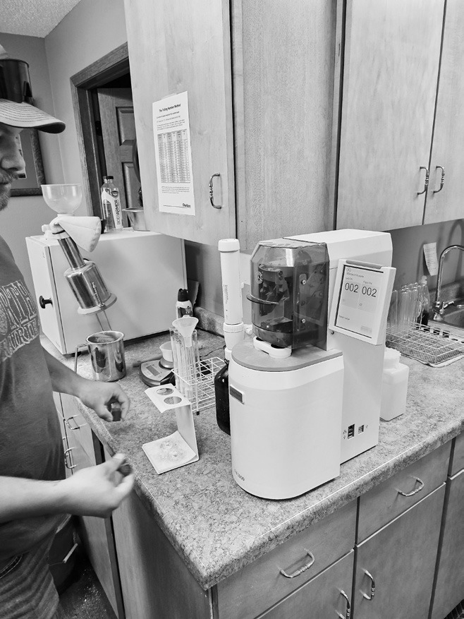 Operations Assistant Chase Rhode checks the quality of one of the hundreds of wheat samples the facility receives. The process is integral due to the tight parameters of the milling industry. Photo by Nick Vorlage.