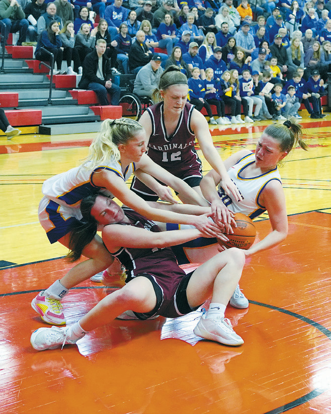 Erika Bakke fights for a loose ball against two Wildcats. Photo by Larry Stokke.